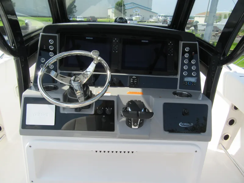 Slide: The Image of 2023 Robalo R250 CC boat dashboard with steering wheel and electronic controls. - 5
