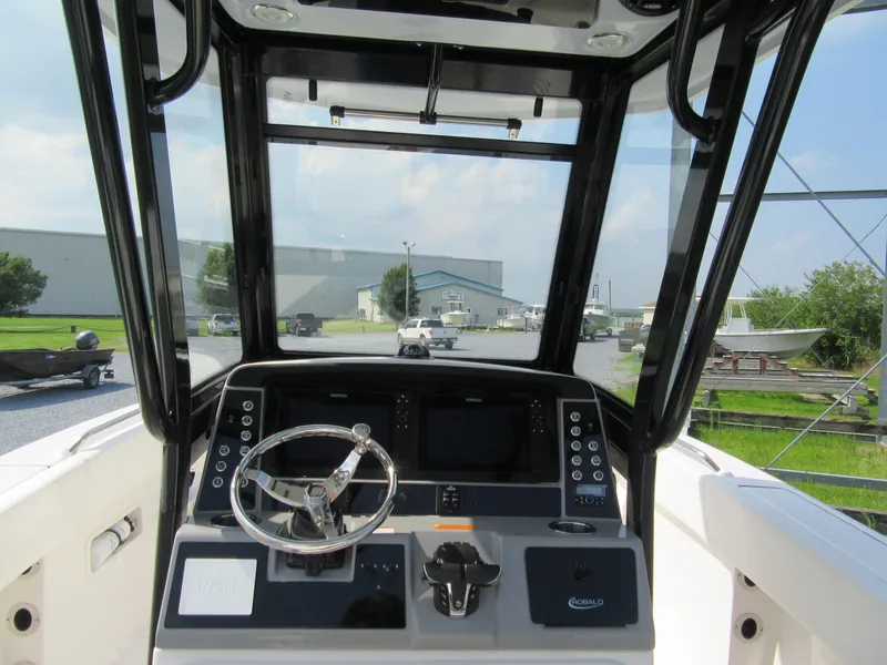 Slide: The Image of 2023 Robalo R250 CC boat helm with steering wheel and control panel. - 6