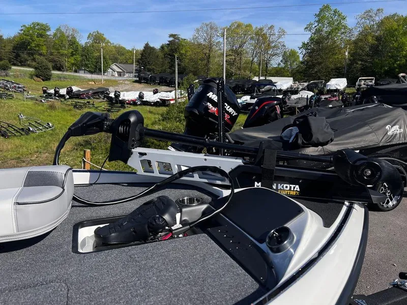 Slide: The Image of 2023 Triton 179 TrX boat with Minn Kota trolling motor in a dealership lot. - 6