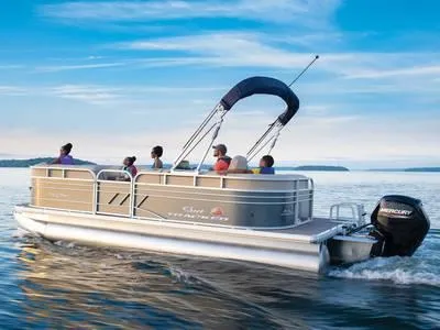The Image of 2023 Sun Tracker PARTY BARGE® 20 DLX pontoon boat on a serene lake. - 1