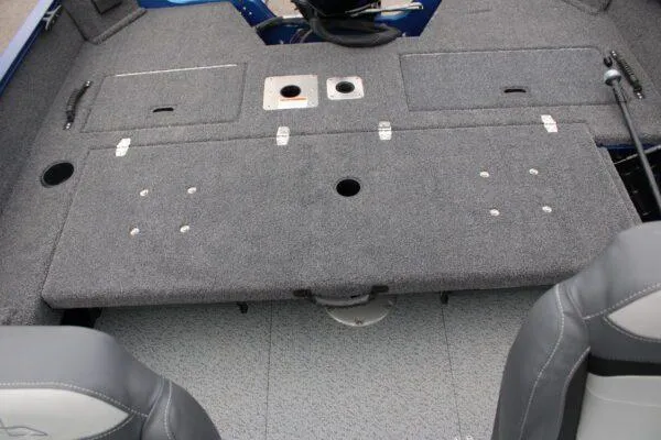 Slide: The Image of 2023 Lowe FM1675 boat interior with gray carpeted deck and storage compartments. - 6