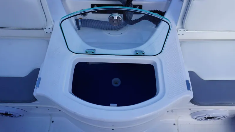 Slide: The Image of Open storage compartment on 2023 Everglades 243 CC boat with glass lid. - 21