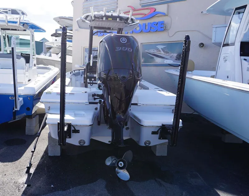 Slide: The Image of 2023 Everglades 243 CC boat with powerful outboard motor, displayed at a dealership. - 29