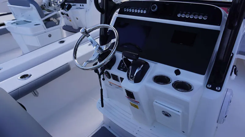 Slide: The Image of 2023 Everglades 243 CC boat dashboard with steering wheel and controls. - 5