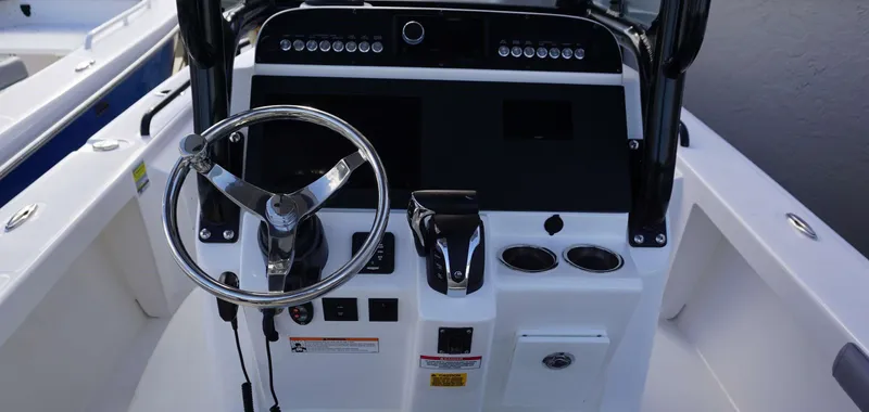 Slide: The Image of 2023 Everglades 243 CC boat dashboard with steering wheel and controls. - 6