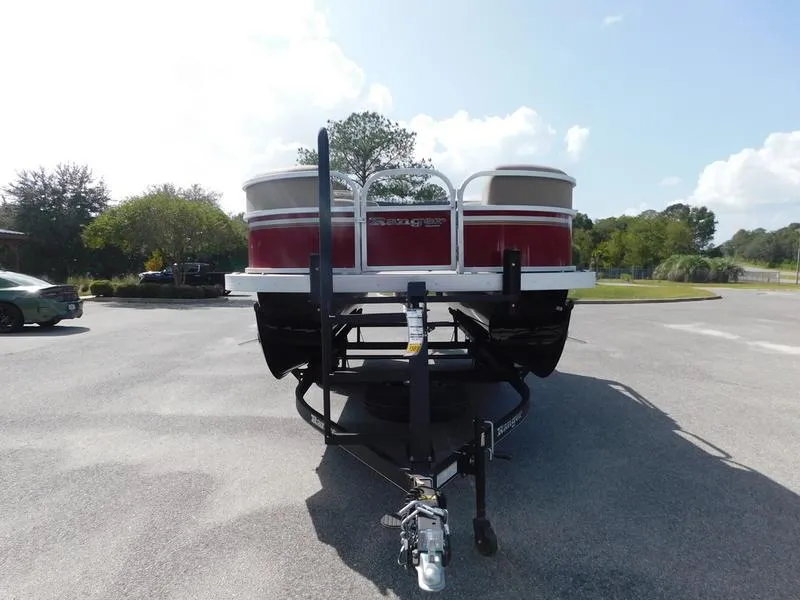 Slide: The Image of 2023 Ranger Reata 200C pontoon boat on a trailer in a parking lot. - 2
