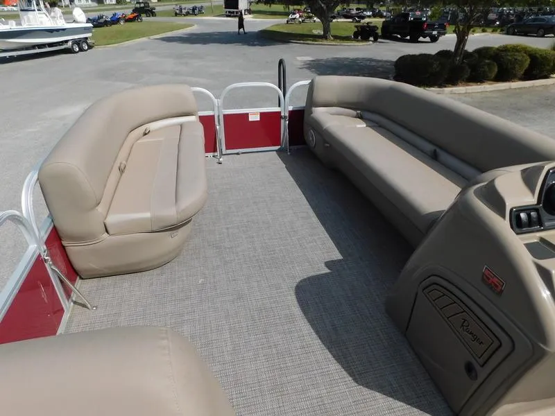 Slide: The Image of 2023 Ranger Reata 200C pontoon boat interior with beige seating and red accents. - 9