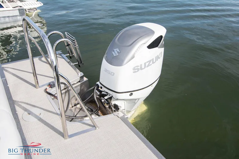 Slide: The Image of 2022 Manitou 25 Encore RF SHP with Suzuki outboard motor on water. - 2