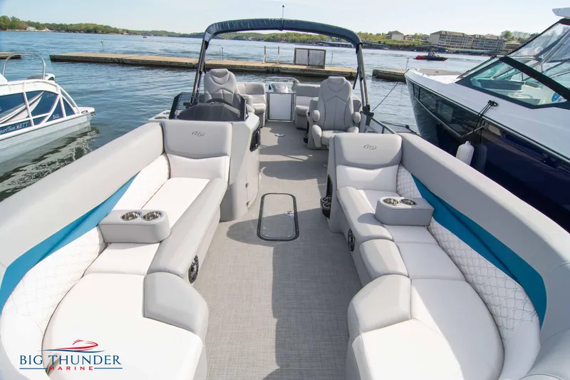 Slide: The Image of 2022 Manitou 25 Encore RF SHP pontoon boat with spacious seating at a marina. - 3