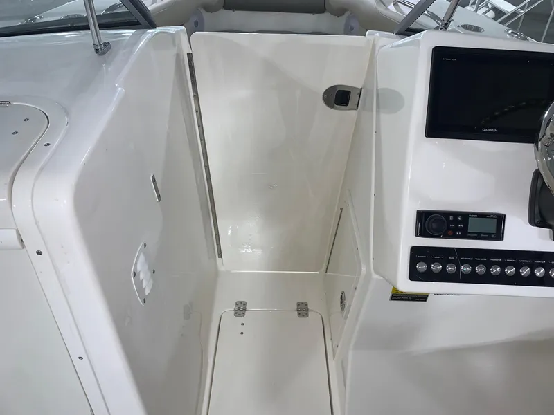 Slide: The Image of 2024 Key West 239 DFS boat interior, helm station with control panel and storage compartment. - 10