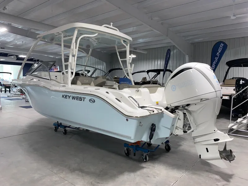 Slide: The Image of 2024 Key West 239 DFS boat in showroom with outboard motor. - 2