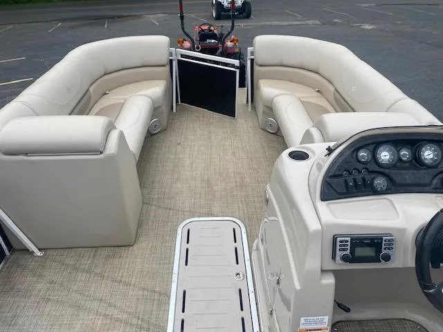 Slide: The Image of 2017 JC 245 TT Spirit pontoon boat interior with beige seating and control panel. - 18