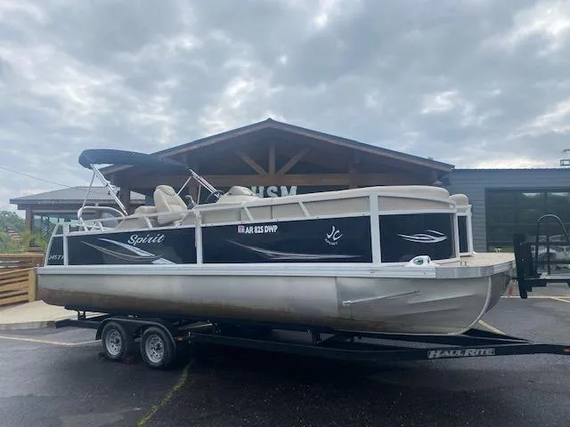 Slide: The Image of 2017 JC 245 TT Spirit pontoon boat on trailer in front of building. - 2