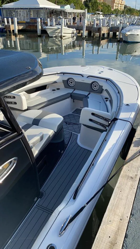 Slide: The Image of 2020 Tidewater 32 boat docked at a marina with luxurious seating. - 14