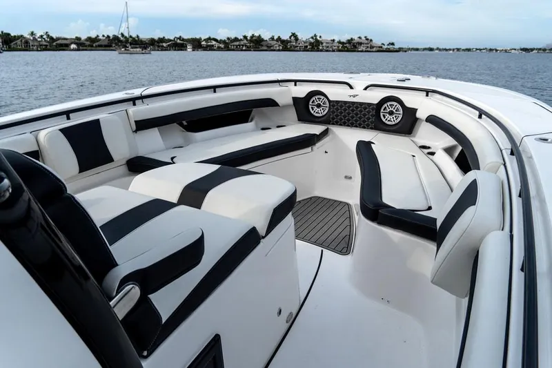 Slide: The Image of 2020 Tidewater 32 boat interior with black and white seating, on a calm water backdrop. - 17