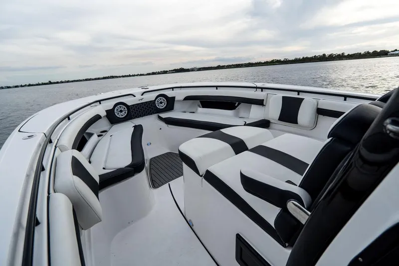 Slide: The Image of 2020 Tidewater 32 boat interior with black and white seating on calm water. - 22