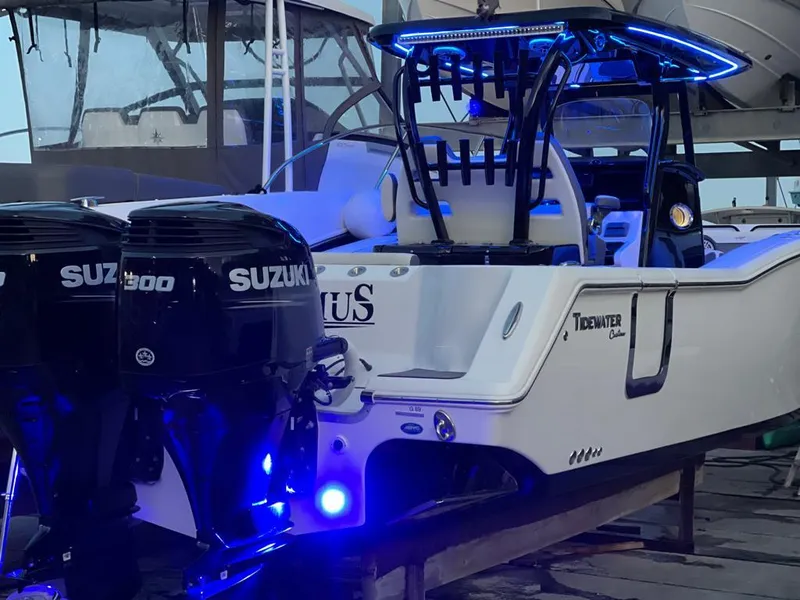 Slide: The Image of 2020 Tidewater 32 boat with dual Suzuki 300 engines, illuminated by blue LED lights. - 5