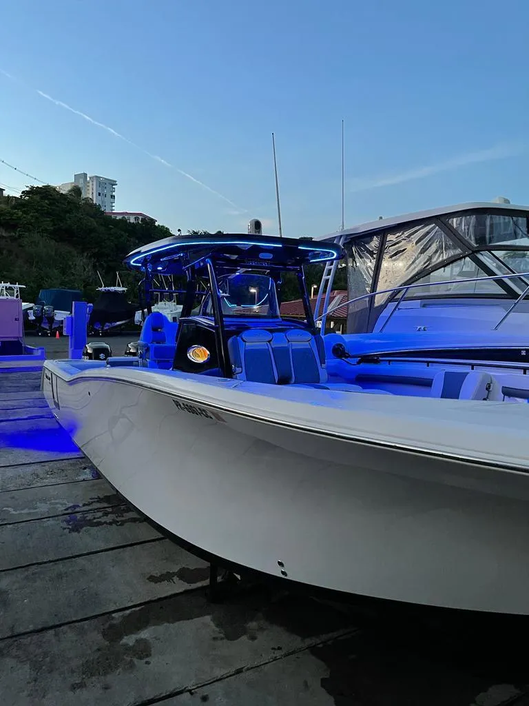 Slide: The Image of 2020 Tidewater 32 boat docked with blue LED lights at dusk. - 6