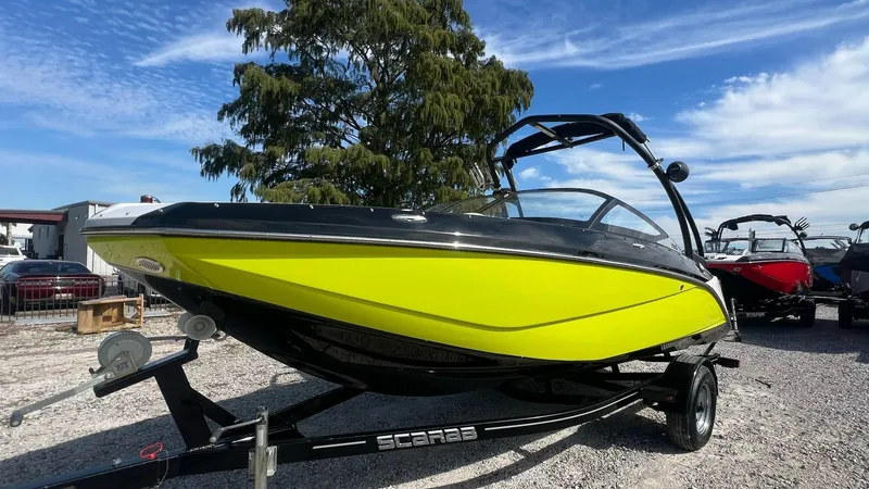 Slide: The Image of 2014 Scarab 195 HO Impulse boat with vibrant yellow hull on trailer. - 16