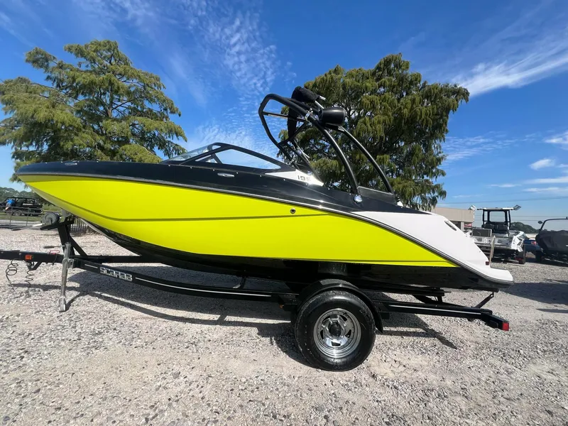 Slide: The Image of 2014 Scarab 195 HO Impulse boat in vibrant yellow on a trailer, parked outdoors. - 17