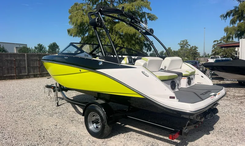 Slide: The Image of 2014 Scarab 195 HO Impulse boat with vibrant yellow and black design on a trailer. - 2