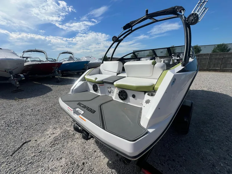 Slide: The Image of 2014 Scarab 195 HO Impulse boat with sleek design, parked on gravel lot. - 21