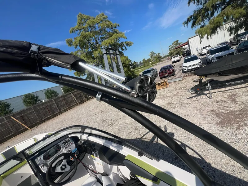 Slide: The Image of 2014 Scarab 195 HO Impulse boat interior with steering wheel and outdoor view. - 8