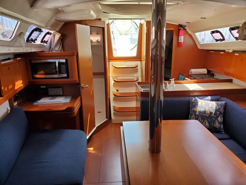 Slide: The Image of Interior of 2014 Beneteau Oceanis 34 sailboat with kitchen, seating, and dining area. - 9