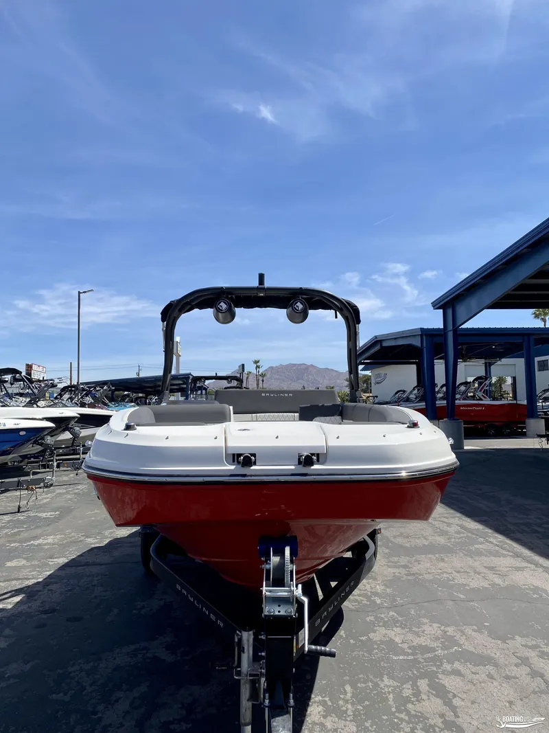 Slide: The Image of 2023 Bayliner DX2050 boat on trailer under clear blue sky. - 2