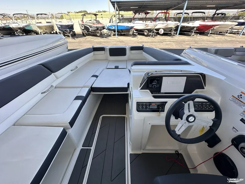 Slide: The Image of 2023 Bayliner DX2050 boat interior with steering wheel and seating area. - 6