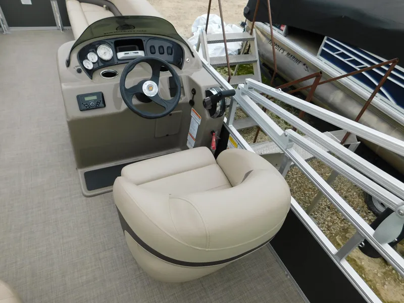 Slide: The Image of 2023 Sun Tracker Party Barge 18 DLX helm with beige captain's chair and control panel. - 11