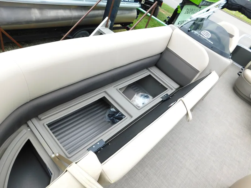 Slide: The Image of 2023 Sun Tracker Party Barge 18 DLX interior seating with storage compartments. - 6