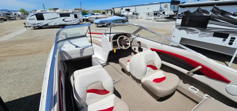 Slide: The Image of 1996 Four Winns 190 Horizon DLX boat interior with white and red seating, parked in a lot. - 17