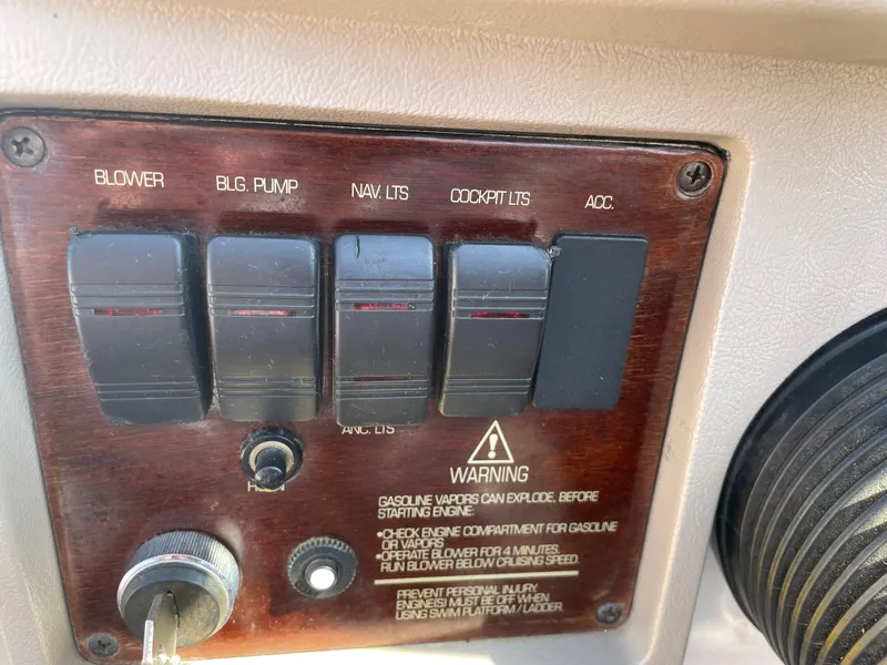 Slide: The Image of Control panel of a 1996 Four Winns 190 Horizon DLX boat with various switches and warning label. - 26