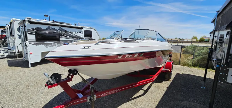 Slide: The Image of 1996 Four Winns 190 Horizon DLX boat on a red trailer in a parking lot. - 3