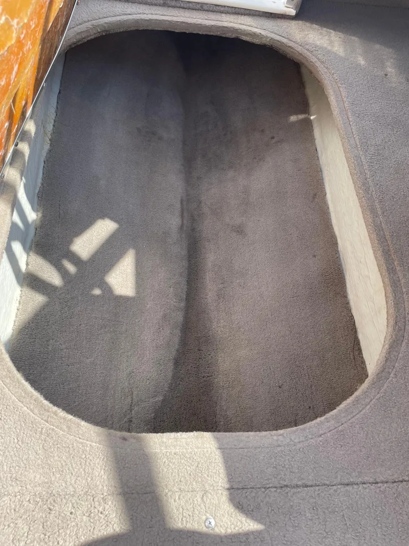 Slide: The Image of Interior view of a 1996 Four Winns 190 Horizon DLX boat with carpeted flooring. - 31