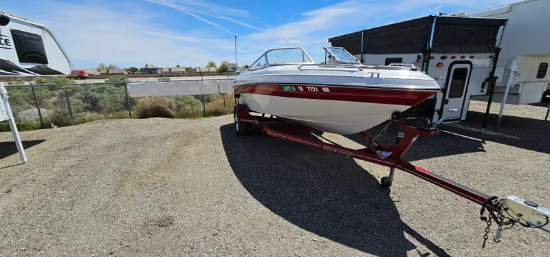Slide: The Image of 1996 Four Winns 190 Horizon DLX boat on a trailer in a parking lot. - 4
