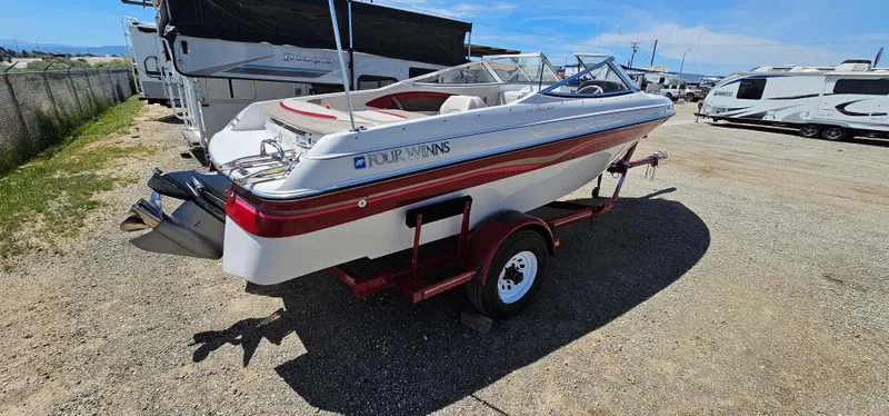 Slide: The Image of 1996 Four Winns 190 Horizon DLX boat on a trailer in a parking lot. - 5