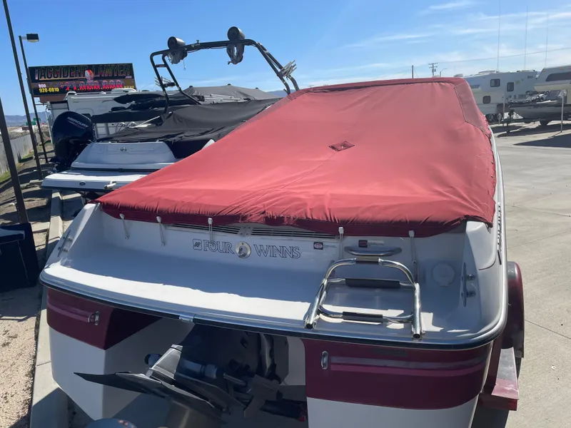 Slide: The Image of 1996 Four Winns 190 Horizon DLX boat with red cover, parked outdoors. - 8
