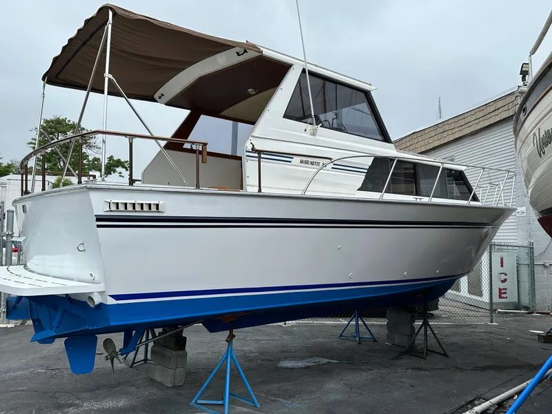 The Image of 1990 Marinette 28 Sport Fish Fly Bridge on stands outdoors. - 0