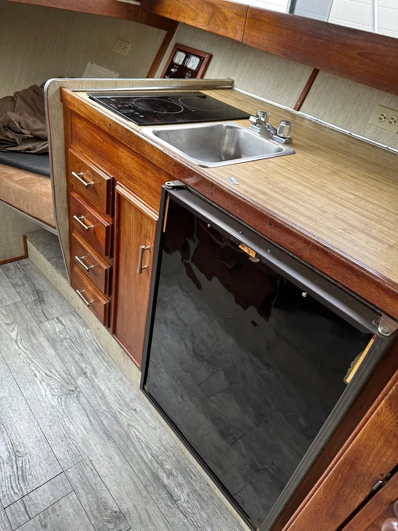 Slide: The Image of Interior of 1990 Marinette 28 Sport Fish Fly Bridge with kitchenette and fridge. - 5