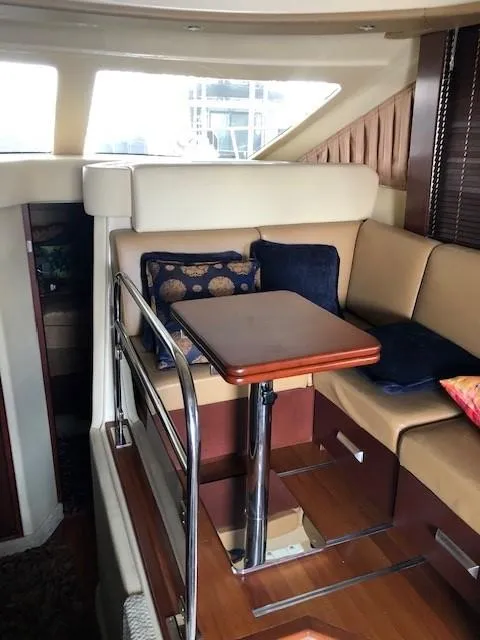 Slide: The Image of 2007 Sea Ray 36 Sedan Bridge interior with cozy seating and wooden table. - 26
