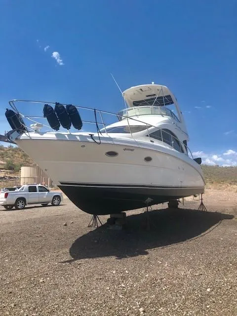 Slide: The Image of 2007 Sea Ray 36 Sedan Bridge yacht on dry land under a clear blue sky. - 36
