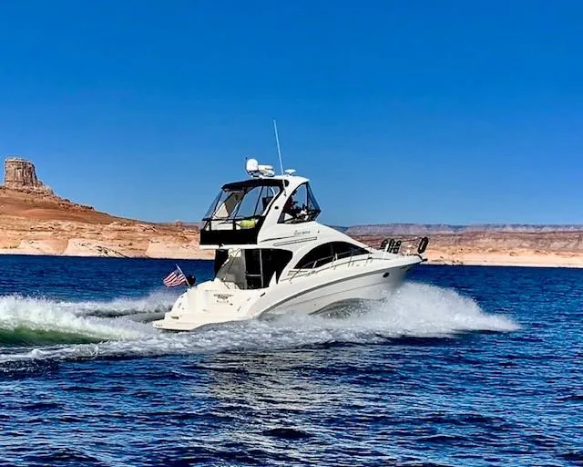Slide: The Image of 2007 Sea Ray 36 Sedan Bridge cruising on a lake with desert landscape. - 4