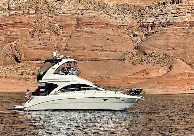 Slide: The Image of 2007 Sea Ray 36 Sedan Bridge yacht cruising near rocky shoreline. - 5