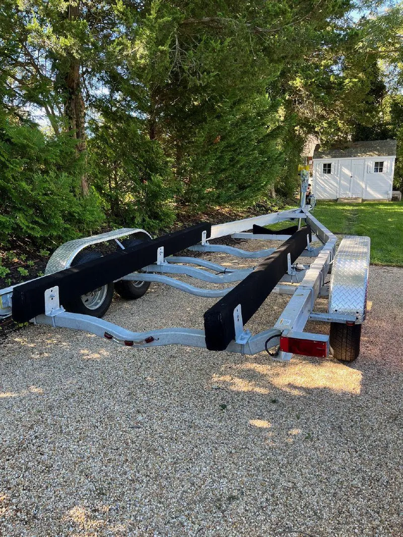 Slide: The Image of Trailer for 2006 Chris-Craft Launch 25 boat parked on gravel driveway. - 9