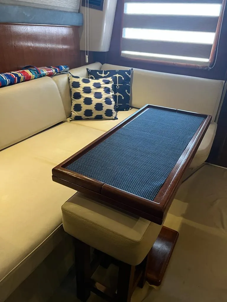 Slide: The Image of 1994 Luhrs 380 Tournament interior with beige seating and wooden table. - 11