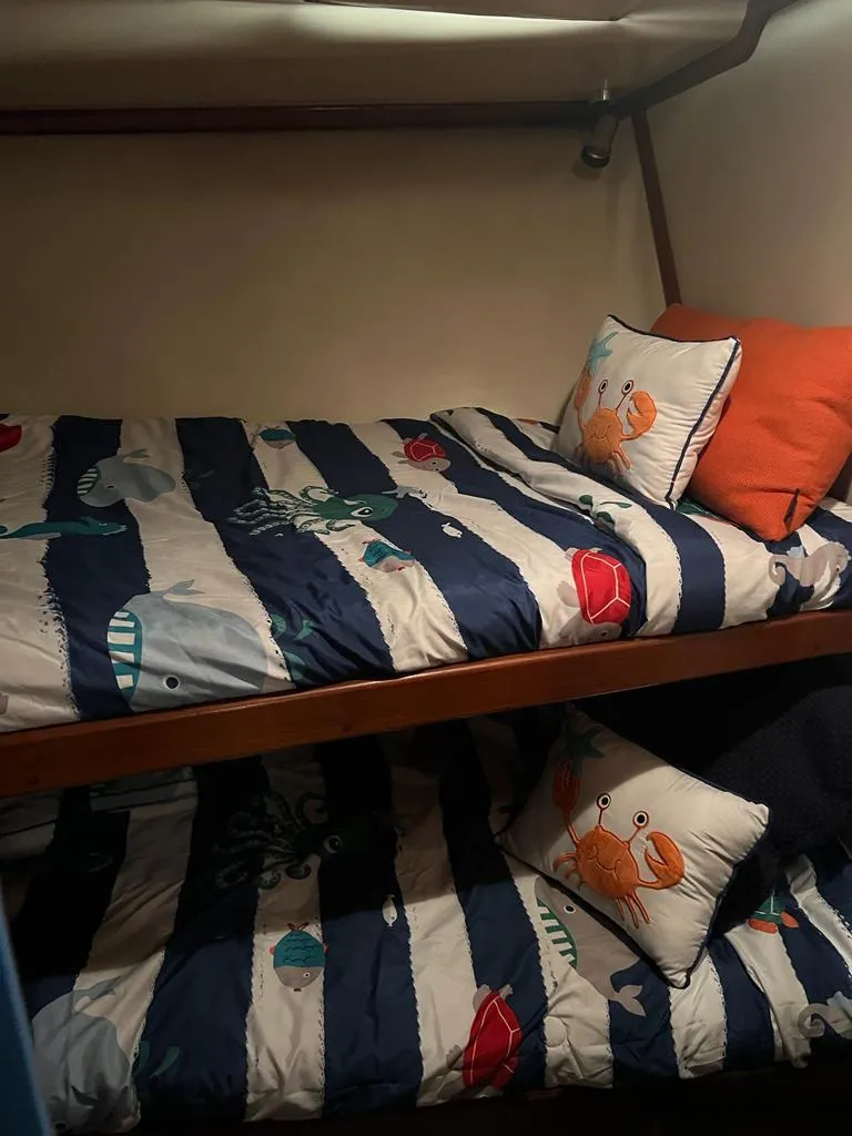 Slide: The Image of Bunk beds with nautical-themed bedding in a 1994 Luhrs 380 Tournament boat cabin. - 19