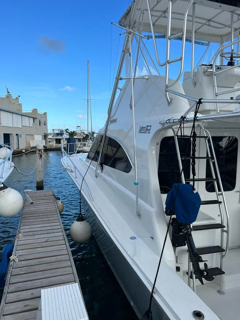 Slide: The Image of 1994 Luhrs 380 Tournament yacht docked at a marina, showcasing sleek design and fishing equipment. - 4