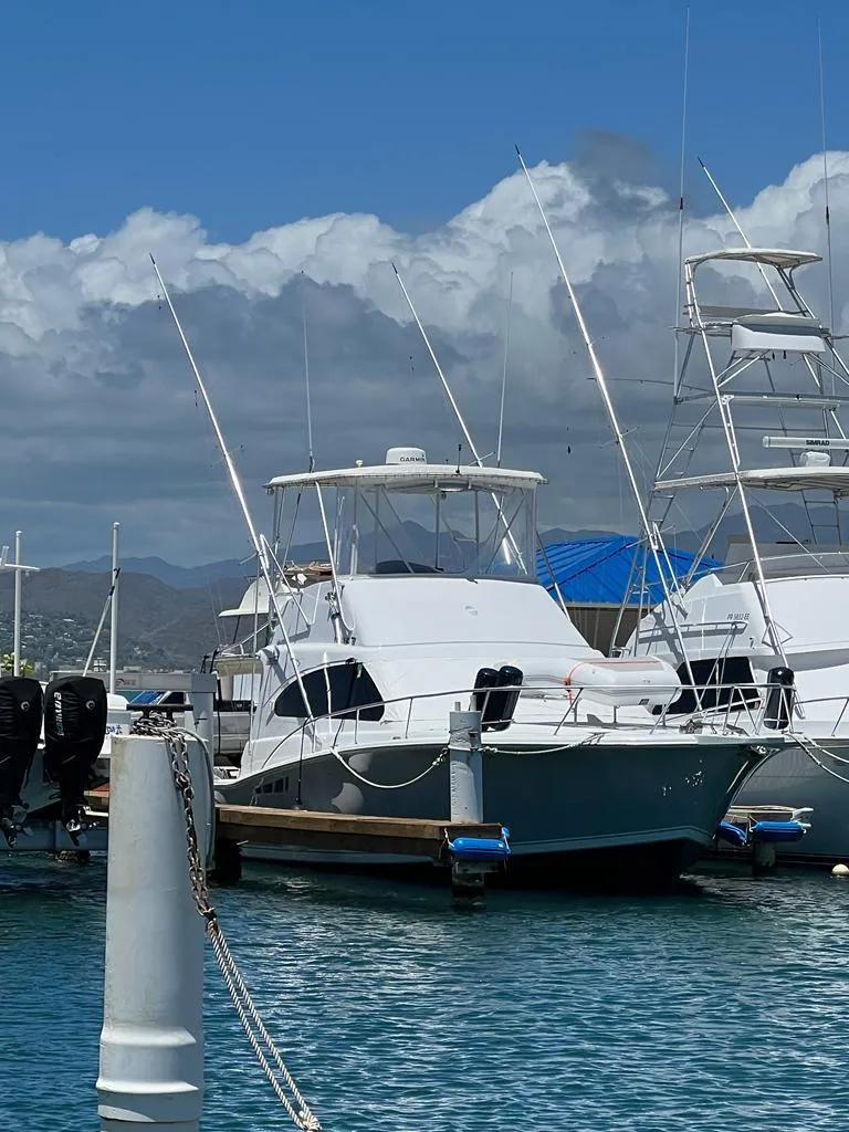 Slide: The Image of 1994 Luhrs 380 Tournament yacht docked at marina under clear blue sky. - 8